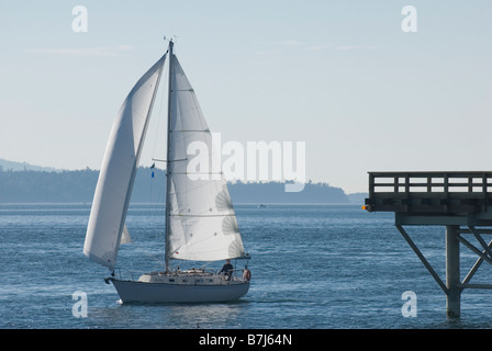 Un voilier passe par le front de Sidney, Sidney, C.-B. Banque D'Images