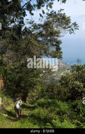dh PORTA DA CRUZ MADEIRA deux randonneurs touristiques sur le sentier de flanc de colline et vue sur la côte nord couple randonneurs sentier de vacances marche Banque D'Images