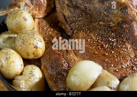 Pommes de terre rôties avec du rôti de porc saupoudré d'épices Banque D'Images