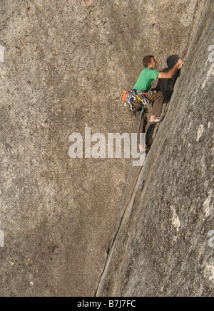 L'homme (20-25), grimpant sur un rocher de granit, de Squamish, en Colombie-Britannique. Banque D'Images