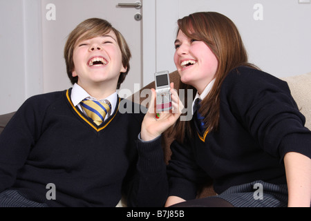 Deux adolescentes rire ensemble sur un téléphone. Banque D'Images