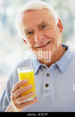 Man Smiling at Camera et boire le jus d'Orange Banque D'Images