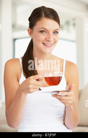 Jeune femme à boire le thé de fines herbes Banque D'Images