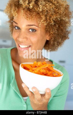 Mid adult Woman Holding un bol de carottes Banque D'Images