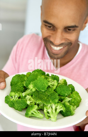 Middle aged Man Holding A Plate Of Broccoli Banque D'Images