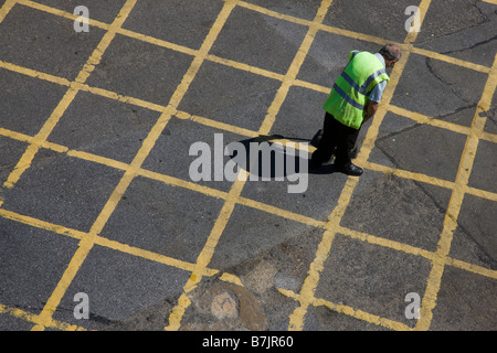 Homme ramasser les déchets dans un road box junction Banque D'Images