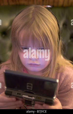 5 ans, fille, jouer au Nintendo DS Lite console Banque D'Images