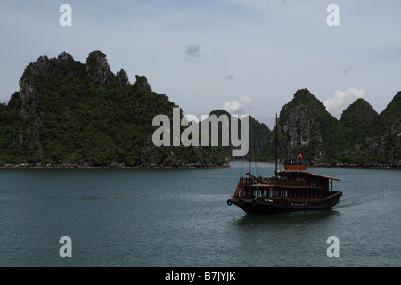 Un bateau de tourisme navigation à travers la baie de Halong Vietnam Banque D'Images