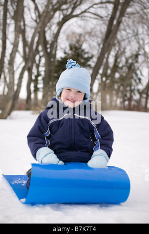 Enfant sur la neige slider, Regina, Saskatchewan, Canada Banque D'Images