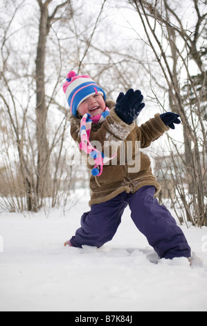 Jeune enfant throwing snow, Regina, Saskatchewan, Canada Banque D'Images