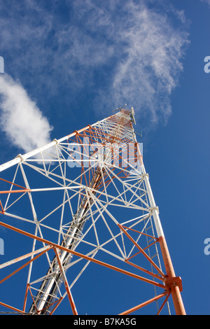 Communications en treillis rouge et blanc mât avec fond de ciel bleu Banque D'Images