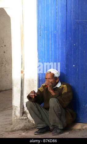 Un homme marocain boissons thé à la menthe sur la rue à Essaouira Banque D'Images