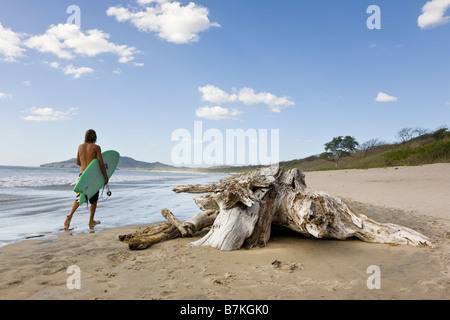 Balades surfer sur la plage du Playa Grande au Costa Rica. Banque D'Images