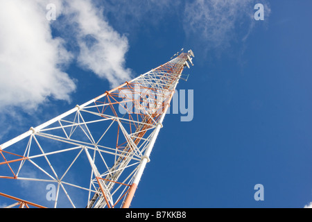 Communications en treillis rouge et blanc mât avec fond de ciel bleu Banque D'Images