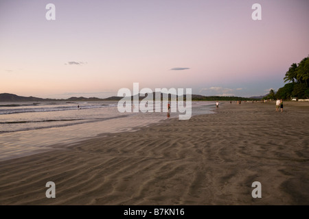 La marche sur la plage après le coucher du soleil à Playa Tamarindo à Guanacaste, Costa Rica. Banque D'Images