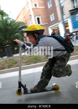 Little Boy riding scooter Banque D'Images