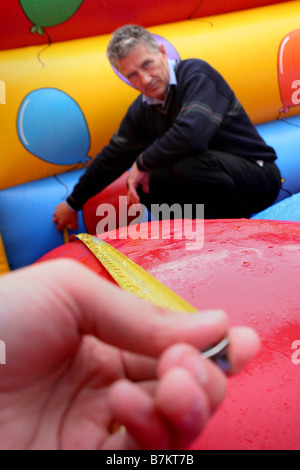 Un inspecteur pour PIPA vérifie un château gonflable est conforme aux règlements Banque D'Images