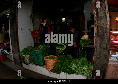 Un matin vendeur ouvert à vendre des légumes dans l'alimentation locale non réglementées dans le marché chinois du résidentiel rues après t Banque D'Images