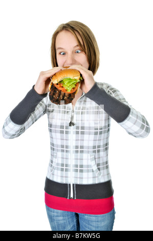 Teenage girl eating a hamburger big isolé sur fond blanc Banque D'Images