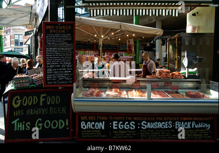 Un boucher décroche à Borough Market, London England UK Banque D'Images