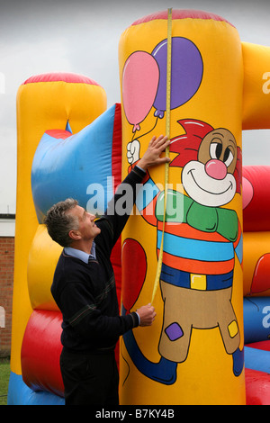 Un inspecteur pour PIPA vérifie un château gonflable est conforme aux règlements Banque D'Images