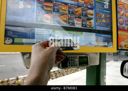 Personne titulaire d'une carte de crédit prêt à balayer au fast food restaurant en voiture, payer l'auto Banque D'Images