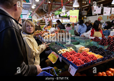 Les consommateurs dans le marché de Granville Island, Vancouver, C.-B., naviguer à travers une large gamme de fruits et légumes frais. Banque D'Images