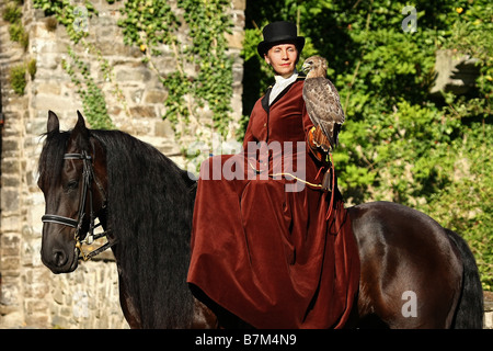 Avec cavalière cheval frison et Hawk Banque D'Images