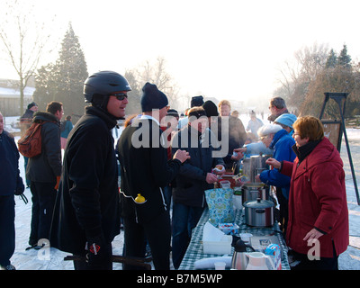 Les personnes vendant des boissons chaudes et de la soupe aux patineurs fatigués sur la glace durant l'molentocht moulin d''Oud Alblas aux Pays-Bas Banque D'Images