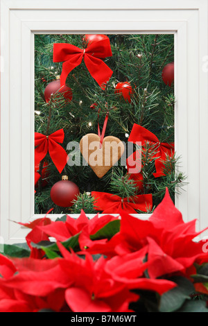 Arbre de noël décoré traditionnellement avec un coeur en pain d'épices et des fleurs rouges beau fond personne vertical aux États-Unis haute résolution Banque D'Images