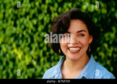 Portrait d'une Latina woman in park smiling. Banque D'Images