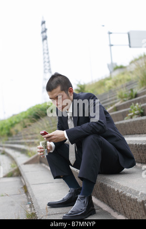 Businessman Holding et la composition d'un téléphone cellulaire Banque D'Images