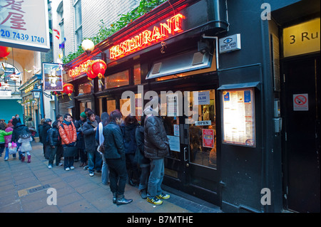 Formulaire à files d'restaurants autour du quartier chinois de Londres au cours de la célébration du Nouvel An chinois. Banque D'Images