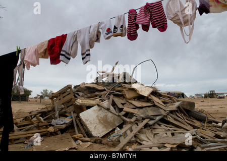 Vêtements sur la corde à linge au milieu de ruines d'une maison démolie par les autorités israéliennes dans un village bédouin non reconnu dans le désert du Neguev dans le sud d'Israël Banque D'Images