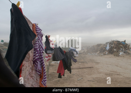 Vêtements sur la corde à linge au milieu de ruines d'une maison démolie par les autorités israéliennes dans un village bédouin non reconnu dans le désert du Neguev dans le sud d'Israël Banque D'Images