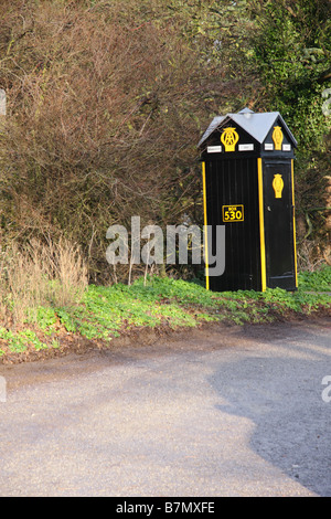 Un ancien style AA téléphone fort par une bordure de pays Banque D'Images