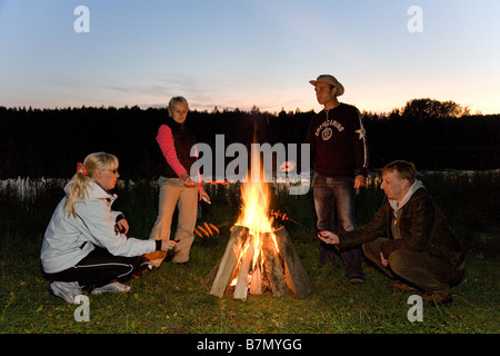 Les amis se détendre par Bonfire, Meenikunno Réserve Paysage, Tallinn, Estonie, Europe Comté Banque D'Images