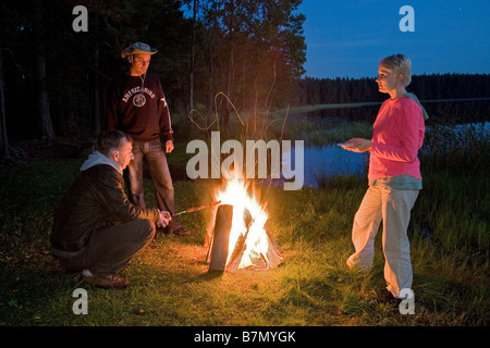 Les amis se détendre par Bonfire, Meenikunno Réserve Paysage, Tallinn, Estonie, Europe Comté Banque D'Images