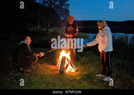 Les amis se détendre par Bonfire, Meenikunno Réserve Paysage, Tallinn, Estonie, Europe Comté Banque D'Images