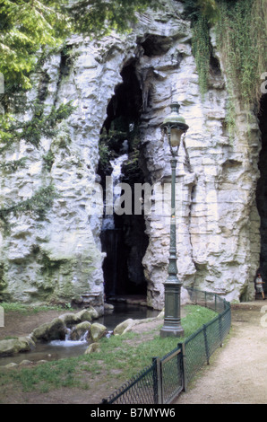 Paris, petit enfant sortant de grotte artificielle dans le Parc des Buttes Chaumont. Banque D'Images