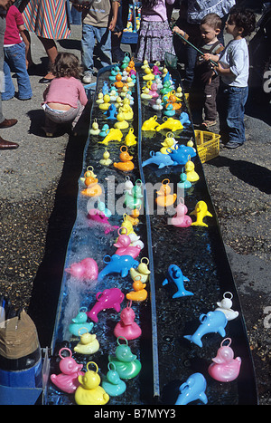 Paris, les enfants jouant avec des canards en plastique et les dauphins dans le Parc des Buttes Chaumont. Banque D'Images