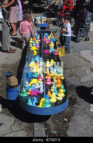 Paris, les enfants jouant avec des canards en plastique et les dauphins dans le Parc des Buttes Chaumont. Banque D'Images