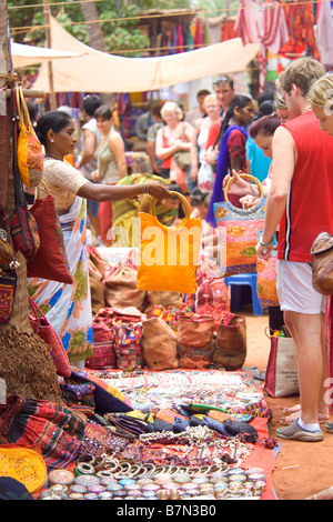 Une scène typique de marché aux puces d'Anjuna Goa avec un exposant en essayant de vendre des marchandises à un touriste. Banque D'Images