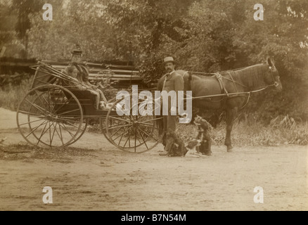 Circa 1900s Photographie d'une famille sur un pays ride avec leur voiture à cheval et des chiens. SOURCE : tirage photographique original. Banque D'Images