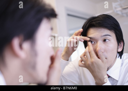 Mettre l'homme dans une lentille de contact Banque D'Images