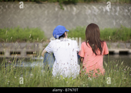 Couple Sitting on Grass, vue arrière Banque D'Images