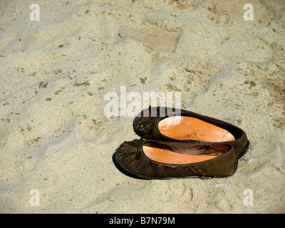 Paire de porte en cuir marron ballerine femmes appartements sur la plage de sable. Banque D'Images