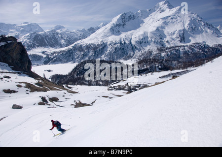 L'alpiniste Ski descend une pente en direction du lac gelé Sils et lac de Silvaplana. Grisons, Suisse Banque D'Images