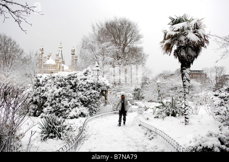 Femme marche dans les jardins, le Royal Pavilion à Brighton couvertes de neige Février 2009 Banque D'Images