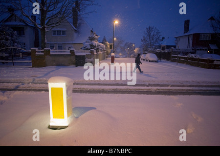 Un matin tôt trudges de banlieue pour travailler le long de Denmark Hill dans le sud de Londres après les chutes de neige inhabituellement Banque D'Images